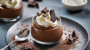A chocolate mousse recipe showing an ultra-smooth, airy chocolate mousse made with 74% dark chocolate, whipped egg whites, and a dollop of cream.
