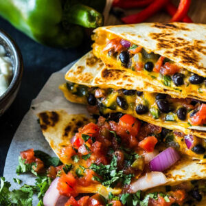 Photo os a vegetarian quesadillas filled with vegetables and oozing cheese.